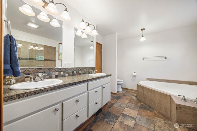 bathroom with vanity, a relaxing tiled tub, and toilet