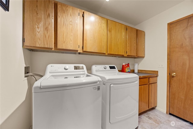 laundry room with washing machine and dryer and cabinets