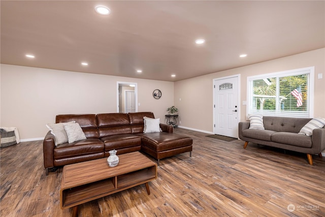 living area featuring baseboards, wood finished floors, and recessed lighting