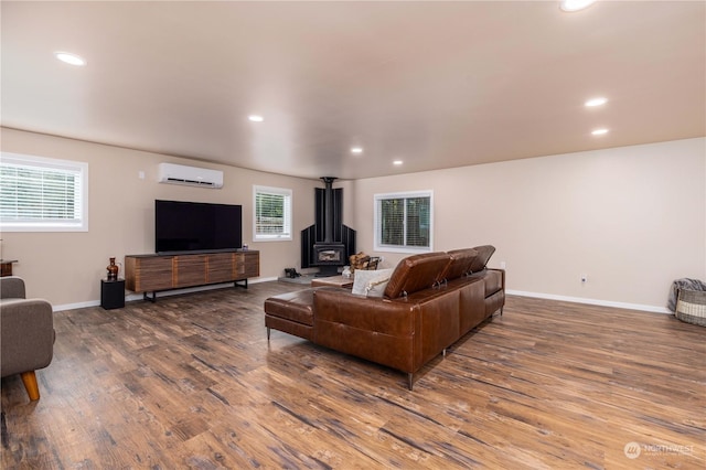 living room featuring a wall unit AC, a wealth of natural light, and wood-type flooring