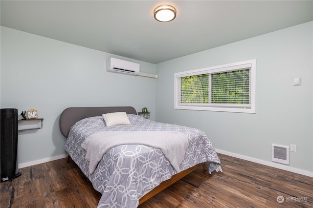 bedroom with visible vents, baseboards, wood finished floors, and a wall mounted AC