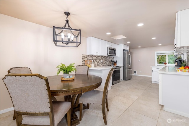 tiled dining space featuring sink and a chandelier