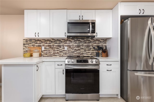 kitchen with backsplash, kitchen peninsula, white cabinetry, and stainless steel appliances