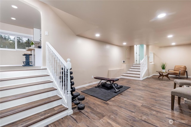 exercise room featuring baseboards, wood finished floors, and recessed lighting