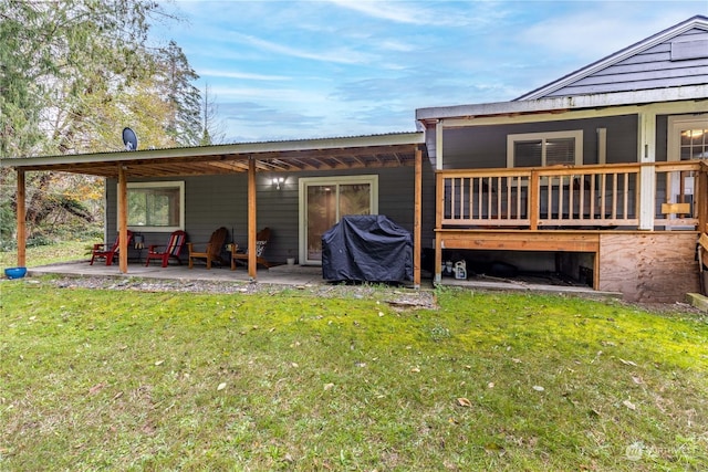 back of house featuring a patio area and a lawn