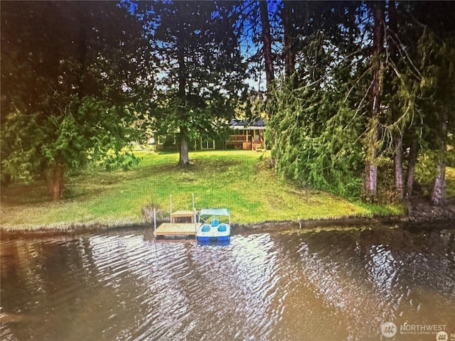 view of dock featuring a water view and a lawn