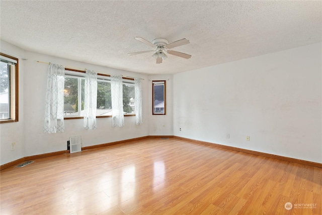 spare room with a textured ceiling, light hardwood / wood-style floors, and ceiling fan