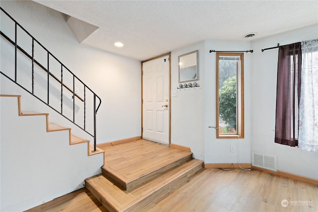 entryway featuring wood-type flooring and a textured ceiling