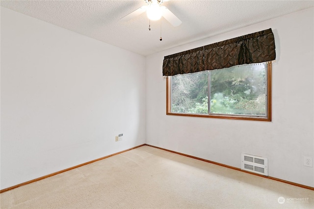 empty room with carpet flooring, a textured ceiling, and ceiling fan