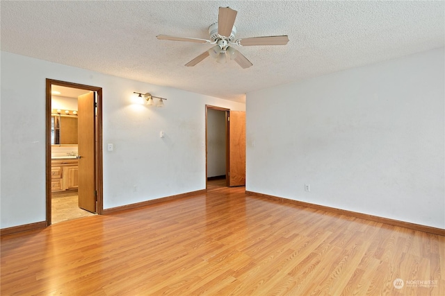 unfurnished room with ceiling fan, a textured ceiling, and light wood-type flooring