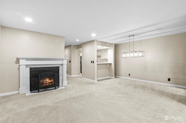 unfurnished living room featuring light colored carpet and a high end fireplace