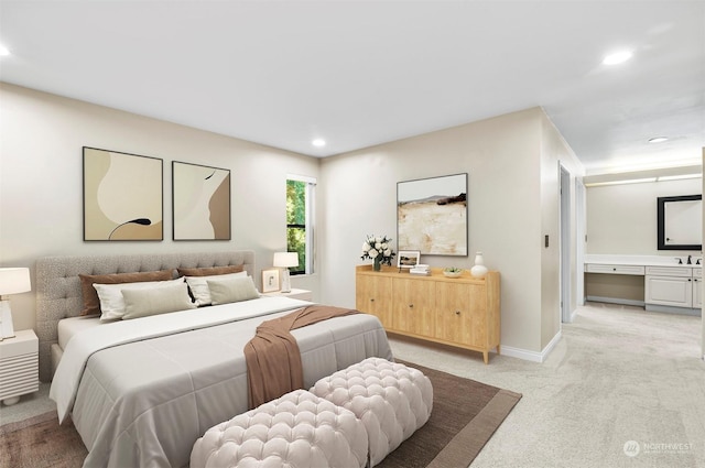 bedroom with ensuite bathroom and light colored carpet