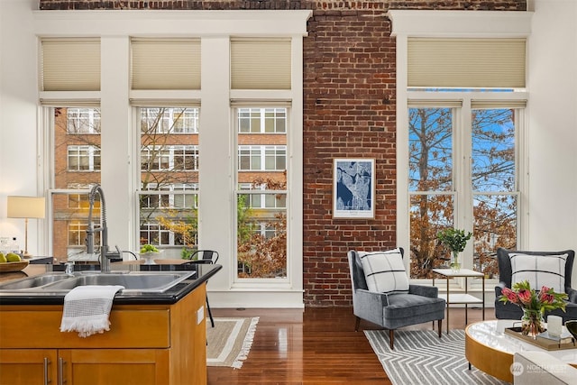 interior space with brick wall, a high ceiling, dark wood-type flooring, and sink