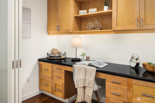 office area featuring dark hardwood / wood-style flooring and built in desk