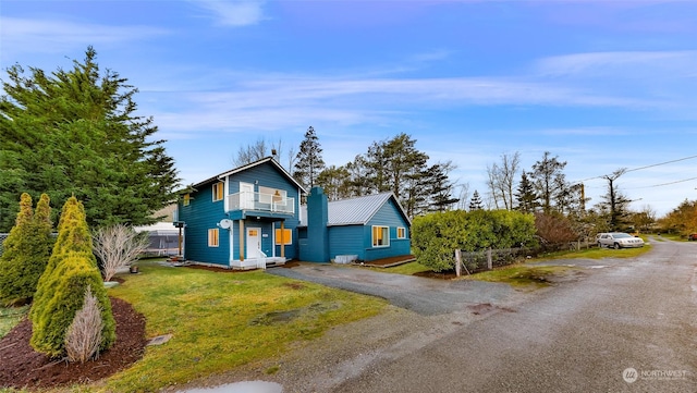 view of front property with a front lawn and a balcony