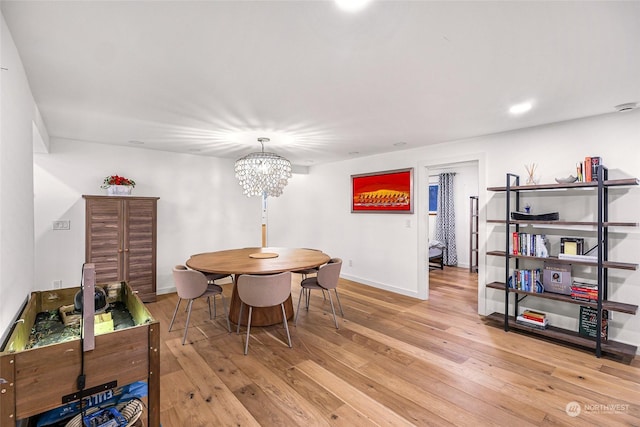 dining area with a chandelier and light hardwood / wood-style flooring