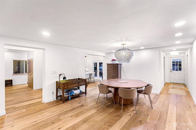 dining space featuring light hardwood / wood-style flooring and a chandelier