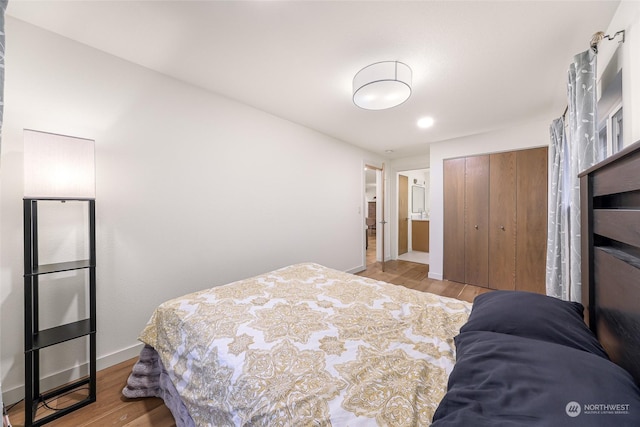 bedroom with light wood-type flooring and a closet