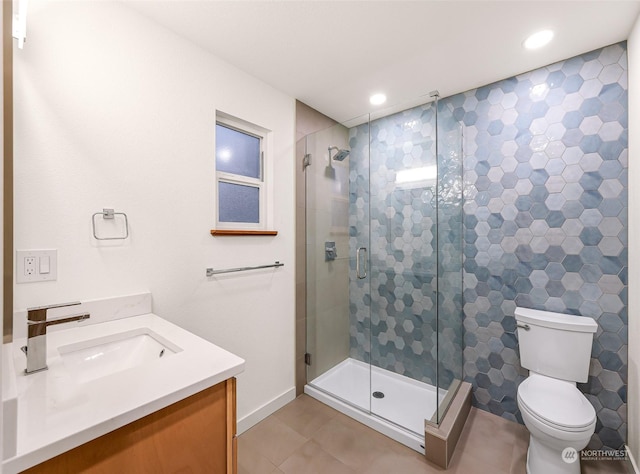 bathroom featuring vanity, a shower with door, toilet, and tile patterned floors