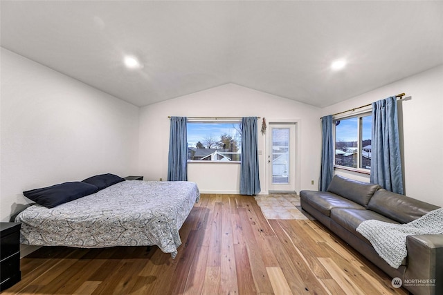 bedroom with hardwood / wood-style floors, vaulted ceiling, and access to exterior