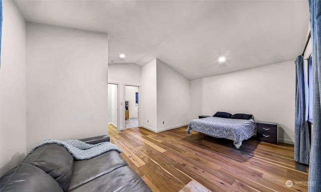 bedroom with wood-type flooring and lofted ceiling