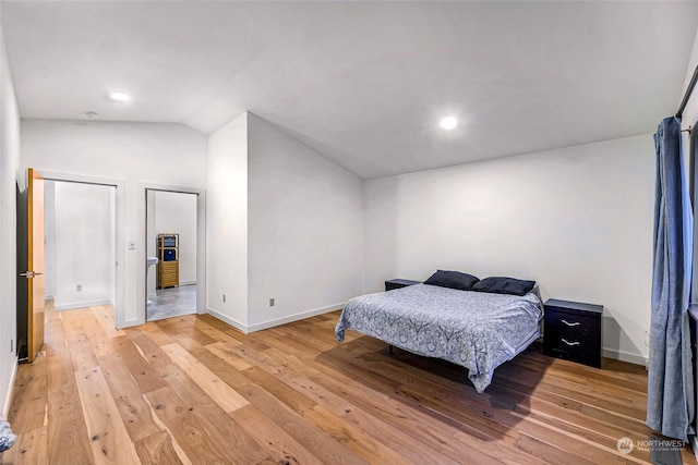 bedroom featuring vaulted ceiling and wood-type flooring