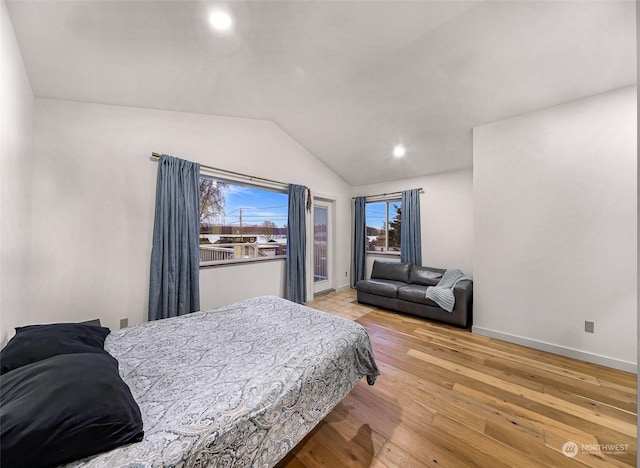 bedroom with light hardwood / wood-style floors and lofted ceiling