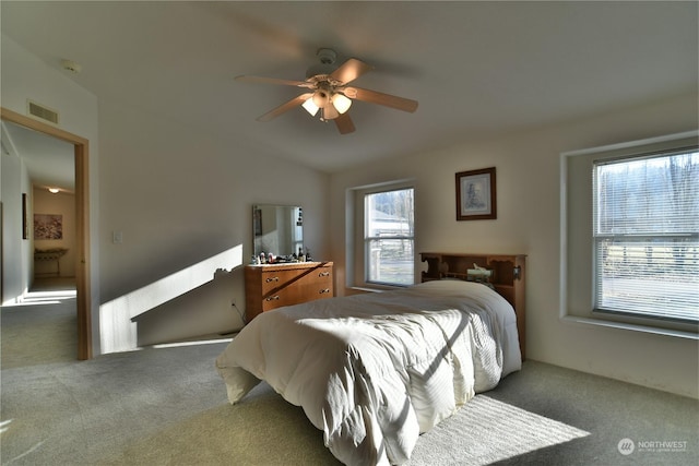 bedroom featuring vaulted ceiling, dark colored carpet, ceiling fan, and visible vents