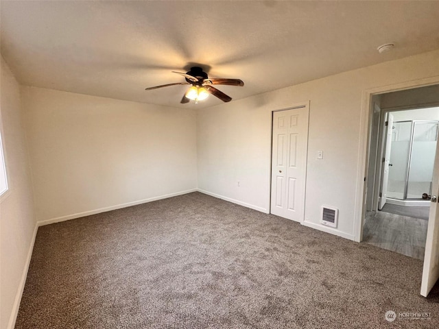 unfurnished bedroom with ceiling fan and dark carpet