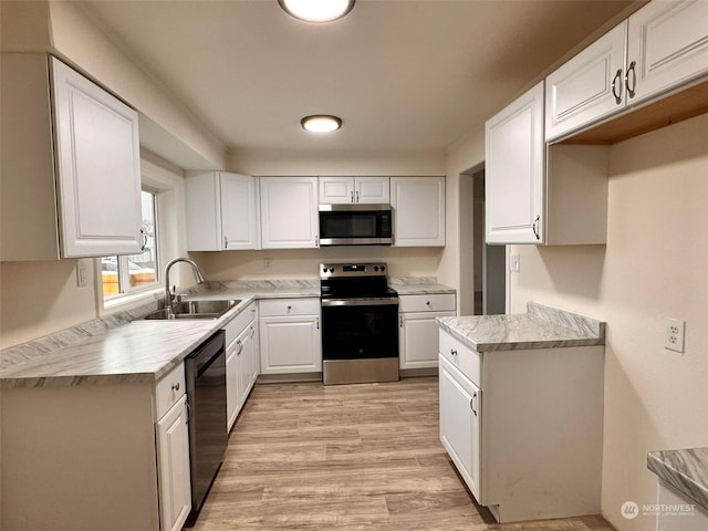 kitchen featuring white cabinets, stainless steel appliances, light hardwood / wood-style flooring, and sink