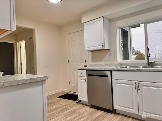 kitchen featuring light stone countertops, light wood-type flooring, sink, dishwasher, and white cabinetry