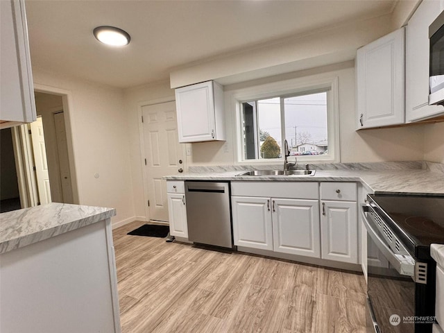 kitchen featuring white cabinetry, sink, stainless steel appliances, and light hardwood / wood-style flooring