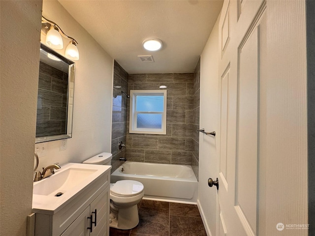 full bathroom featuring tile patterned flooring, vanity, toilet, and tiled shower / bath