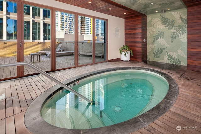 view of pool featuring an indoor in ground hot tub and a wooden deck