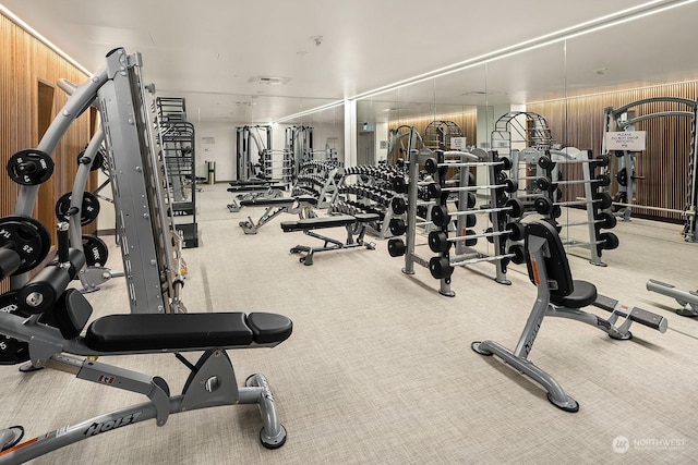 workout area with light carpet and wooden walls