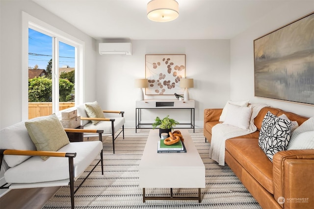 sitting room featuring a wall unit AC and light hardwood / wood-style flooring