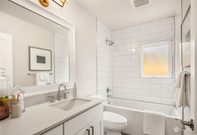 full bathroom featuring tiled shower / bath combo, toilet, and vanity