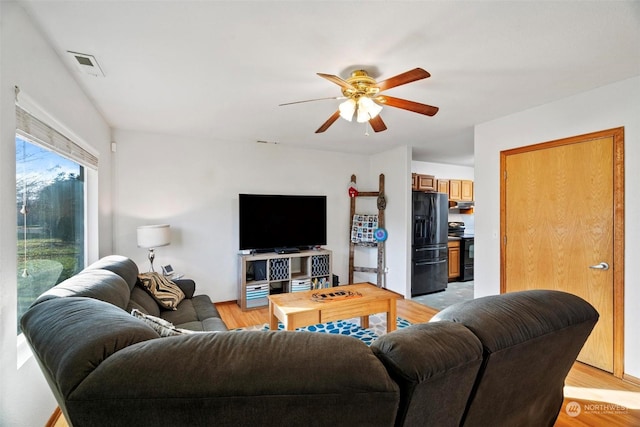 living room with ceiling fan and light hardwood / wood-style flooring