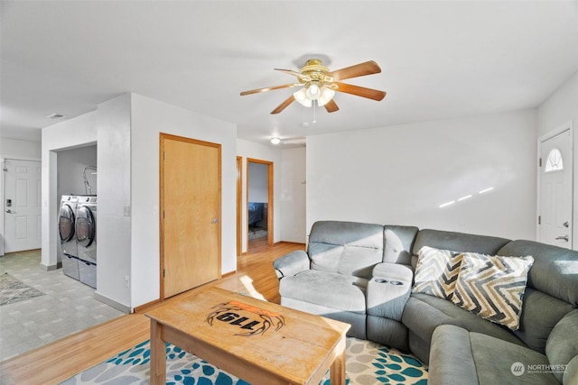 living room featuring light wood-type flooring, washing machine and dryer, and ceiling fan