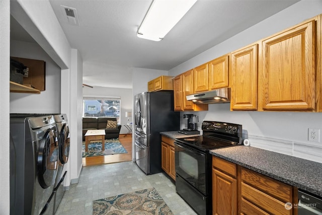 kitchen with independent washer and dryer, light hardwood / wood-style flooring, appliances with stainless steel finishes, and dark stone counters