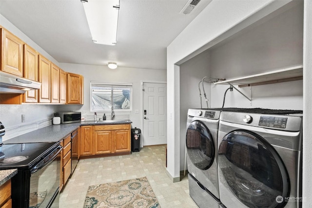 clothes washing area with washing machine and clothes dryer