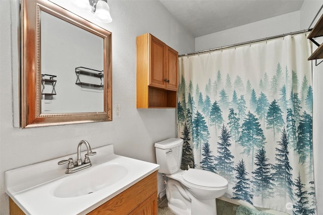 bathroom featuring curtained shower, vanity, and toilet