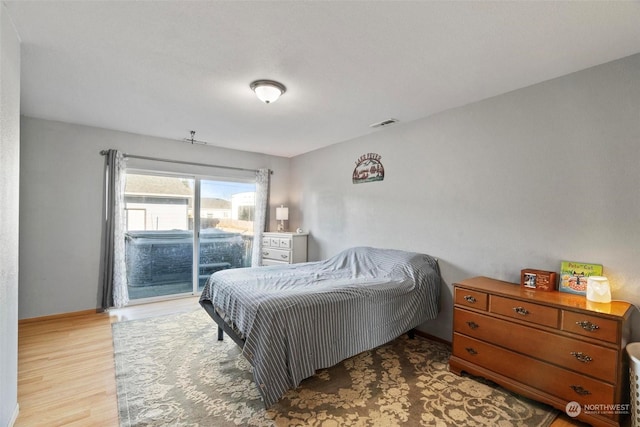 bedroom with access to exterior and light hardwood / wood-style floors