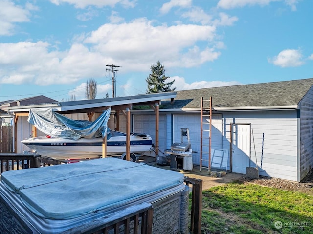 rear view of house with a hot tub and a garage