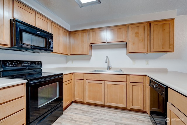 kitchen featuring light wood-type flooring, sink, and black appliances