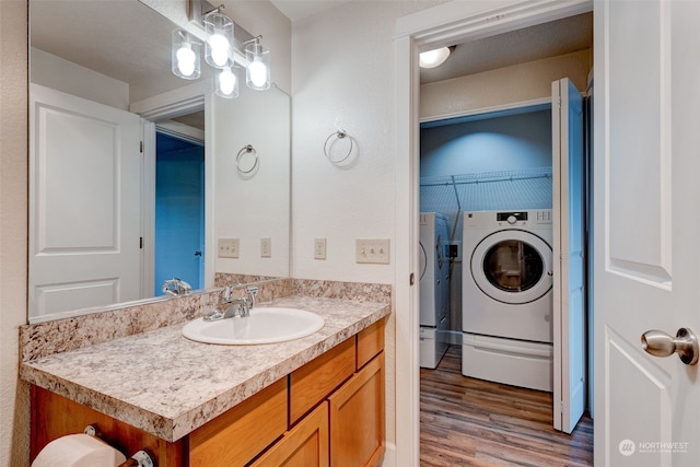 bathroom with wood-type flooring, vanity, a textured ceiling, and washer and clothes dryer