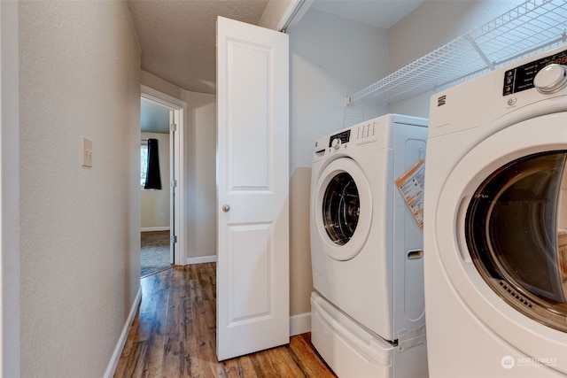 clothes washing area with wood-type flooring and separate washer and dryer