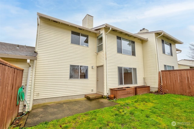 rear view of property featuring a patio area and a lawn