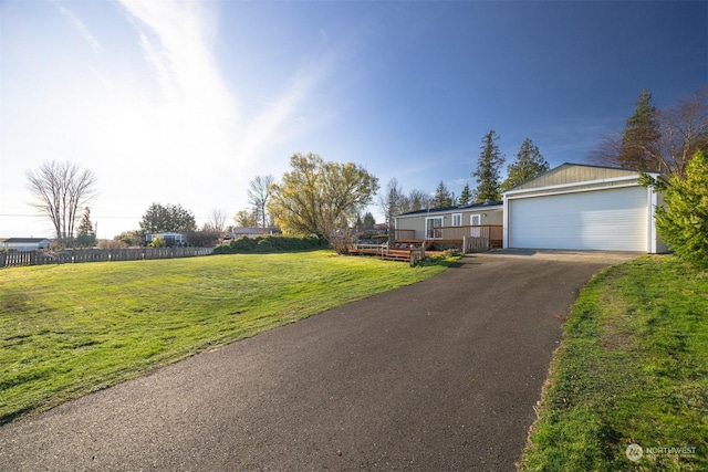 view of front of house featuring a wooden deck, a front yard, and a garage