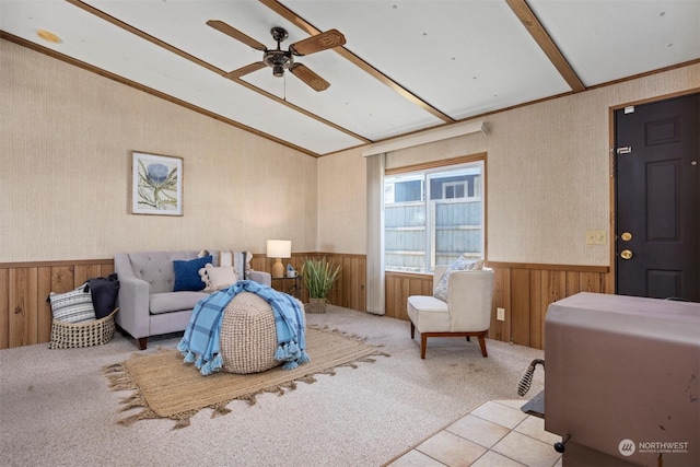 carpeted living room featuring ceiling fan, lofted ceiling with beams, and wood walls